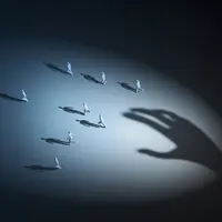 Graphic of little people running away from a giant hand 