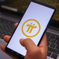 Hand holding a smartphone bearing the Pi Network logo Hand holding a smartphone bearing the Pi Network logo