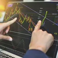 Fingers pointing at a trading chart