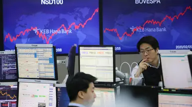 Traders sitting at computer screens Traders sitting at computer screens