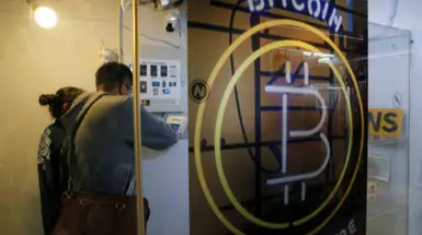 A bitcoin symbol on a glass-fronted business A bitcoin symbol on a glass-fronted business