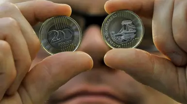 A man holding two coins in front of his eyes A man holding two coins in front of his eyes