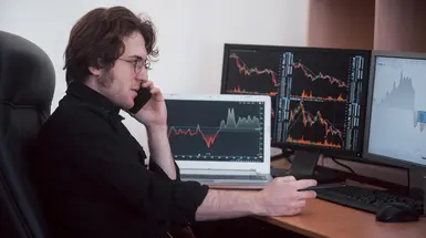Stock trader with charts on screen Stock trader with charts on screen