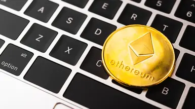 Representation of a golden ETH token resting on a computer keyboard Representation of a golden ETH token resting on a computer keyboard