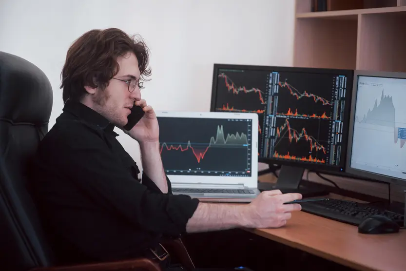 Stock trader with charts on screen
