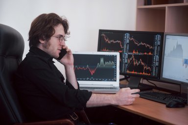 Stock trader with charts on screen